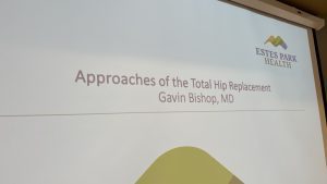 Presentation slide titled "Approaches of the Total Hip Replacement" by Gavin Bishop, MD, from Estes Park Health.