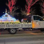 A truck decorated with lights and a stupa floats down a street for a "Christmas in Nepal" event.