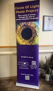 A banner for the Circle of Light Photo Project featuring a close-up image of an eye. It promotes awareness through cornea transplant recipients' photos. Contains logos and a QR code.